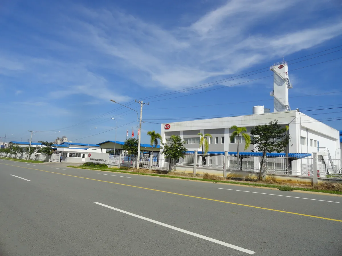 Industrial gas plant building with a white tower, seen from the road