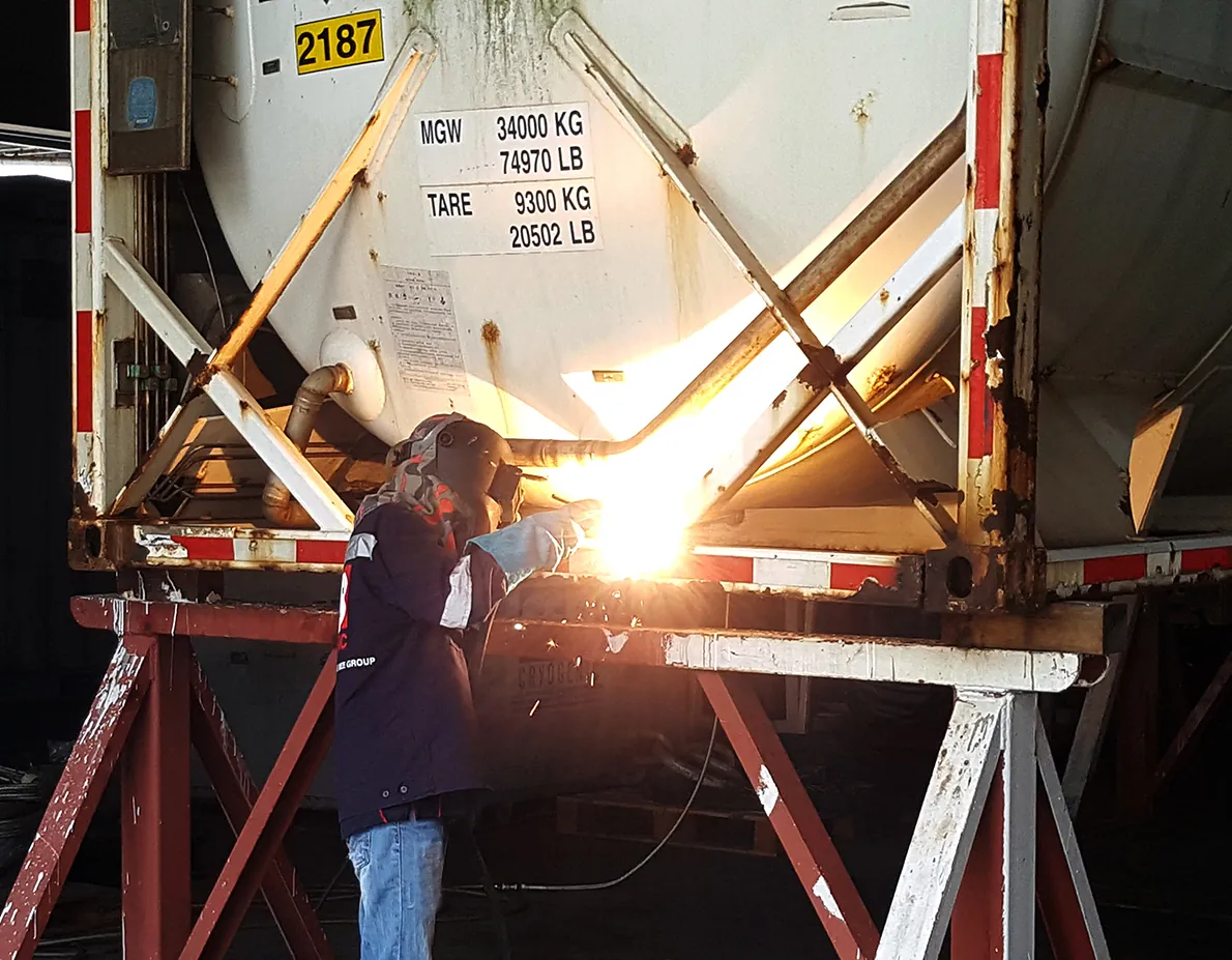 Technician welding on a cryogenic ISO tank frame